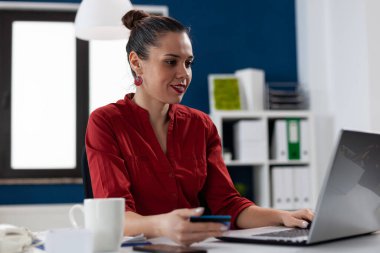 İnternet bankacılığı için laptop kullanan kırmızı gömlekli girişimci.