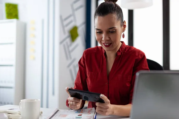 Usmívající se podnikatel s přestávkou hrát mobilní hry na startu kanceláře. — Stock fotografie