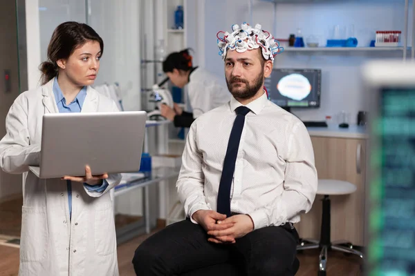 Chercheur femme médecin tapant les symptômes de la maladie neurologique sur ordinateur portable — Photo