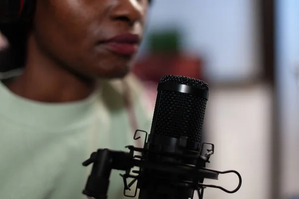 Nahaufnahme einer afrikanisch-amerikanischen Vloggerin, die in ein professionelles Mikrofon spricht — Stockfoto