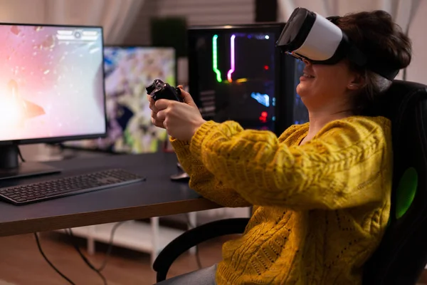 Vrouw gamer het dragen van virtual reality bril met joystick spelen ruimte shooter videogames — Stockfoto