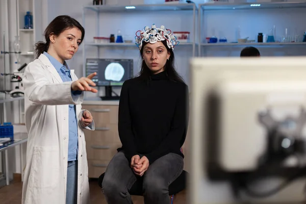 Médico neurologista mostrando experiência em medicina para paciente mulher com fone de ouvido eeg — Fotografia de Stock