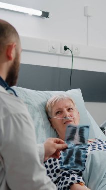 Hasta bir hastayla görüşmek için röntgen taramasına bakan doktor.