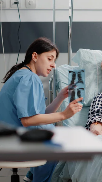 Asistente médico apuntando al escáner de rayos X para mujeres mayores con enfermedad —  Fotos de Stock