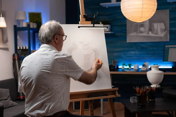 Homem mais velho desenhando desenho a lápis original de vaso de gesso sentindo-se criativo no cavalete — Fotografia de Stock