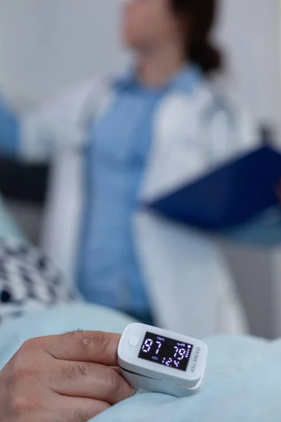 Pulzus-oximéter közelsége a beteg ujján, amely alacsony oxigéntelítettséget mutat sebészeti beavatkozást követően — Stock Fotó