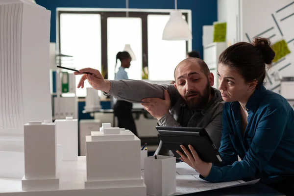 Arkitektingenjör pekar penna på skyskrapa skum modell samarbetar med kollega ingenjör — Stockfoto