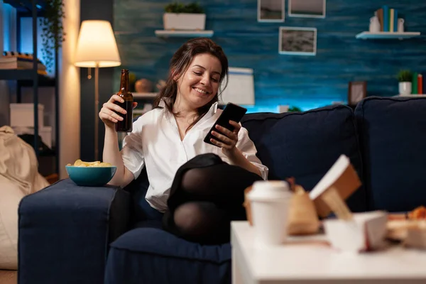 Gelukkig persoon hebben plezier browsen smartphone terwijl het drinken van bier zitten comfortabel op de bank — Stockfoto