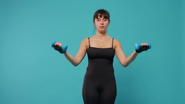 Mujer en forma levantando pesas para entrenar los músculos de los brazos delante de la cámara — Vídeos de Stock