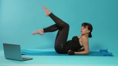 Stüdyoda bacak kaslarını çalıştırmak için bisiklet egzersizi yapan aktif kişi.