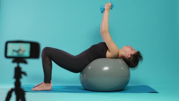 Tutorial de entrenamiento de grabación de mujer con pesas y pelota tonificadora de fitness — Vídeos de Stock