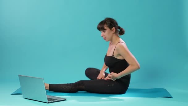 Fit Frau macht Dehnübungen und sieht Meditationsvideo — Stockvideo
