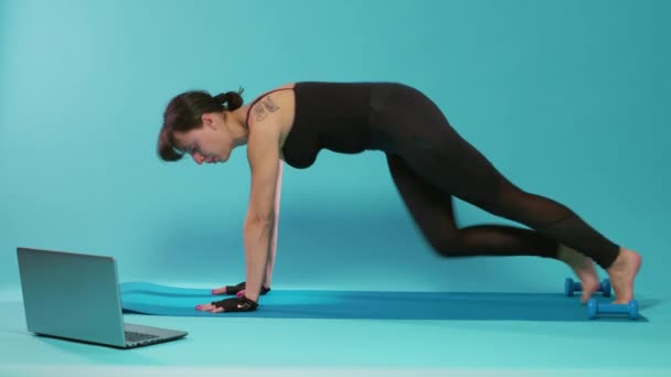 Mujer activa haciendo ejercicio físico en la lección de entrenamiento en línea — Vídeo de stock