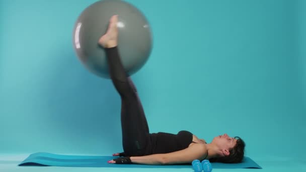 Genç yetişkin kaldırma fitness tonlama topu bacak kasları çalıştırmak — Stok video