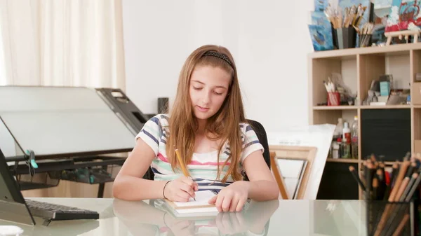 Молода школярка пише математику на ноутбуці — стокове фото