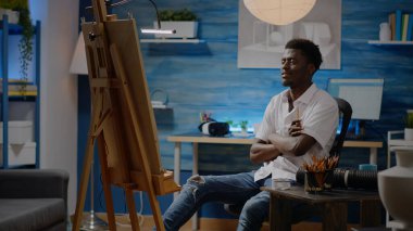 Afro-Amerikan kökenli yetişkin tuvale vazo dizayn ediyor.