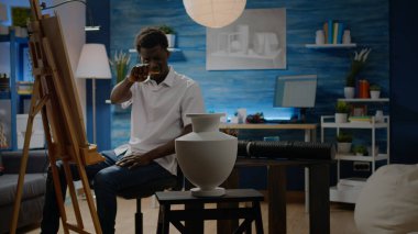 Afrikalı Amerikalı adam sanatsal proje için vazo çiziyor