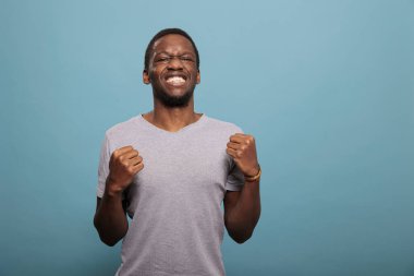 Neşeli ve heyecanlı adam büyük başarıyı yumruklarıyla kutluyor.