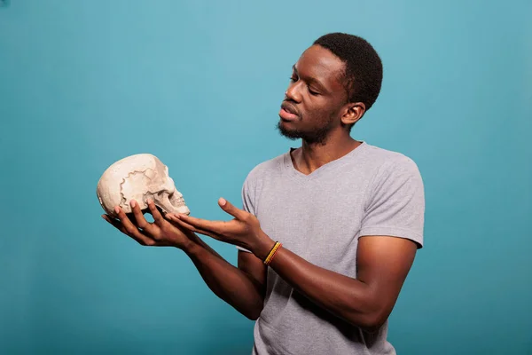 Ευτυχισμένο μοντέλο κρατώντας κρανίο από ανθρώπινο σκελετό στο χέρι — Φωτογραφία Αρχείου
