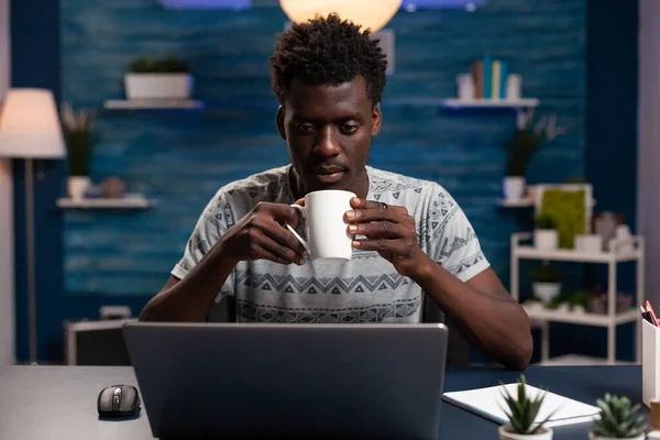 İş adamı elinde fincanla iş projesini okurken kahve içiyor. — Stok fotoğraf