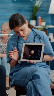 Engelli hasta dijital tablette virüs animasyonuna bakıyor