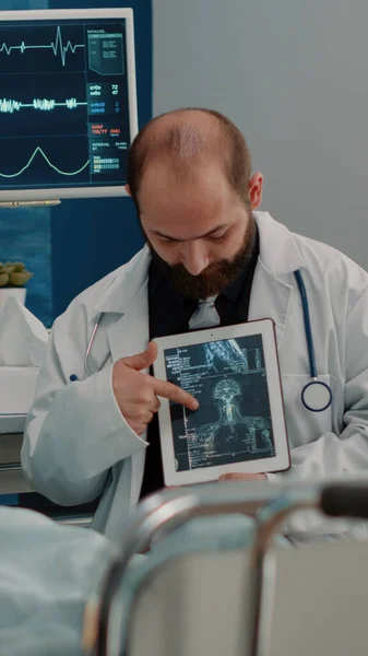 Lékař ukazující osteopatii rentgen na tabletu starší ženě — Stock fotografie