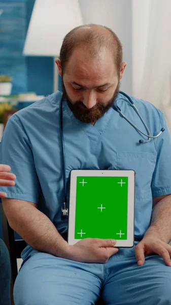 Muž zdravotní sestra vertikálně drží zelenou obrazovku na tabletu — Stock fotografie
