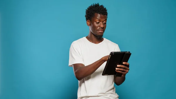 Afrikaanse Amerikaanse man met behulp van digitale tablet en glimlachen — Stockfoto