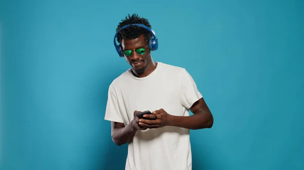 Person jumping and listening to music while using smartphone — Stock Photo, Image