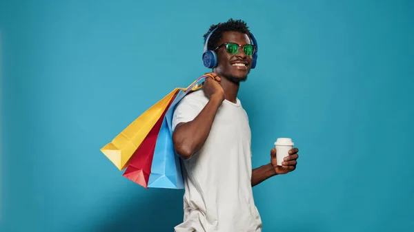 Casual άνθρωπος που μεταφέρουν τσάντες ψώνια και φορώντας ακουστικά — Φωτογραφία Αρχείου