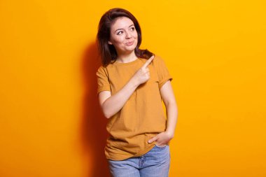 Stüdyonun sağ tarafını işaret etmek için işaret parmağı kullanan pozitif yetişkin