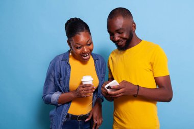 Modern çift akıllı telefona bakıyor ve gülüyor.