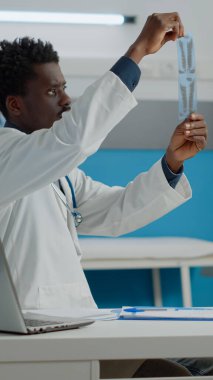 Afro-Amerikan etnik kökenli doktor röntgen analizi yapıyor.