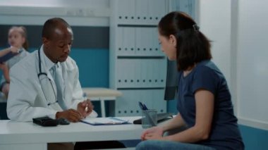 Erkek doktor muayene randevusunda annemle konuşuyor.