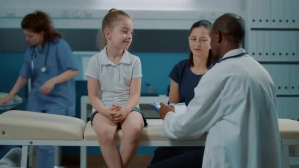 Μικρό κορίτσι μιλάει με το γιατρό στο check up στο υπουργικό συμβούλιο — Αρχείο Βίντεο