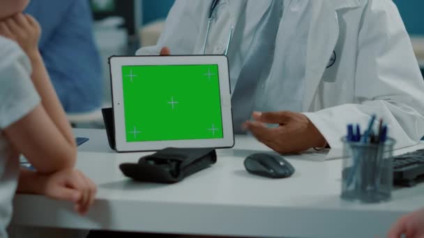Врач общей практики держит планшет с горизонтальным зеленым экраном — стоковое видео
