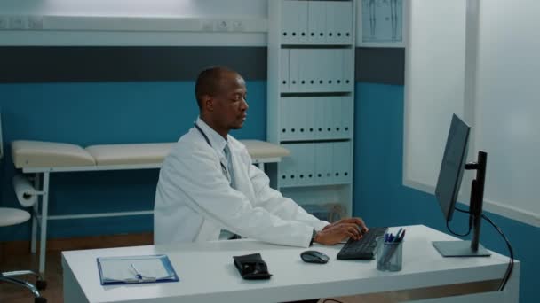 非洲裔美国医生在橱柜中使用计算机的肖像 — 图库视频影像