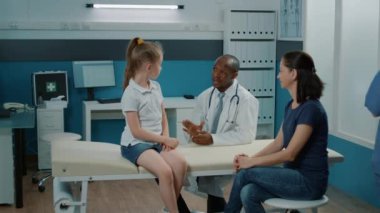 Arkadaş canlısı doktor, sağlık kontrolünde neşeli çocuğa beşlik çakıyor.