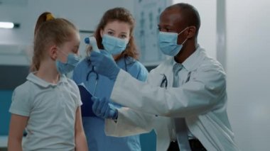 Sıcaklığı termometreyle ölçen doktor ve hemşire