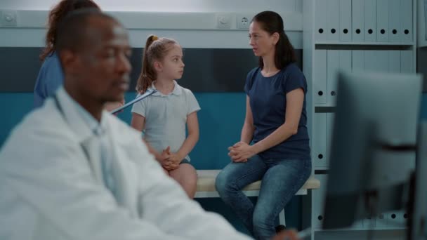 Enfermera conversando con un niño y una madre — Vídeos de Stock