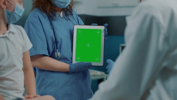 Pielęgniarka gospodarstwa tabletki cyfrowe z zielonym tle ekranu — Wideo stockowe