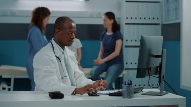 带听诊器在计算机上工作的非裔美国医生 — 图库视频影像