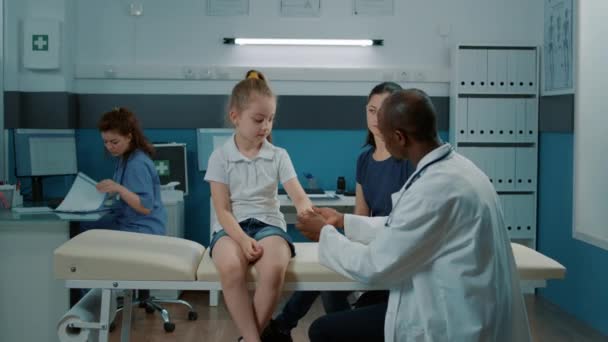 負傷した腕を持つ負傷した子供は医師と相談する — ストック動画