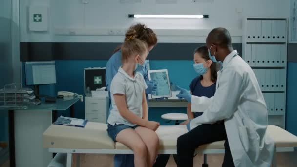 Équipe médicale diversifiée montrant l'image du squelette humain sur tablette — Video