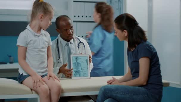 Ο γιατρός εξηγεί τη διάγνωση της οστεοπάθειας στην οθόνη του δισκίου — Αρχείο Βίντεο