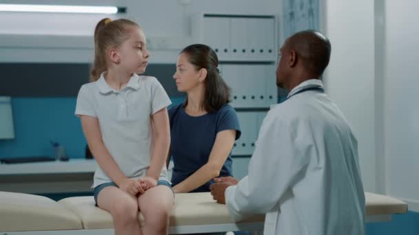 Pediatriker som visar röntgenresultat för mor och barn — Stockvideo