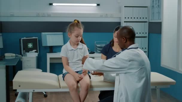 General practitioner applying bandaid on fractured arm of little girl — Stock Video