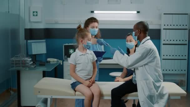 방사선 분석 결과를 어린 소녀와 부모와 함께 분석하는 의사 — 비디오