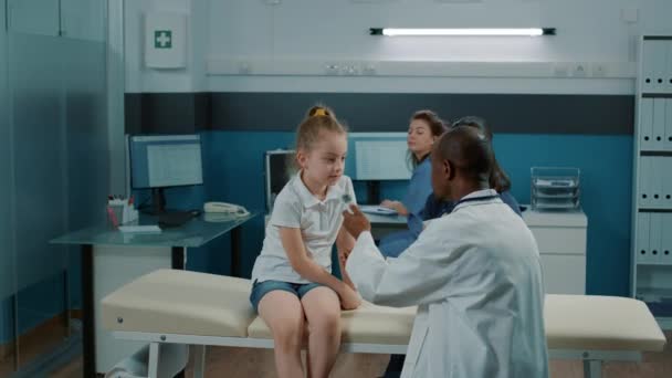 Gesundheitsspezialist benutzt Thermometer bei kleinem Mädchen, um Fieber zu kontrollieren — Stockvideo
