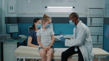 Sıhhiye, küçük çocuğa yapılan kontrolde teşhis koymak için not alıyor